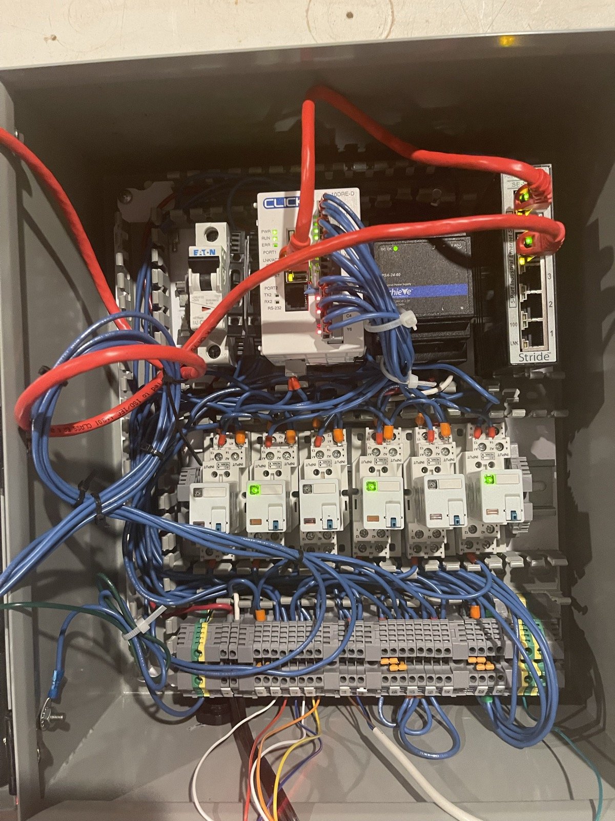 Panel interior: CLICK PLC, Ethernet switch, power supply, breaker, six interposing relays, and terminal strips